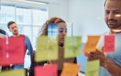 Group of designers brainstorming with notes on a glass wall