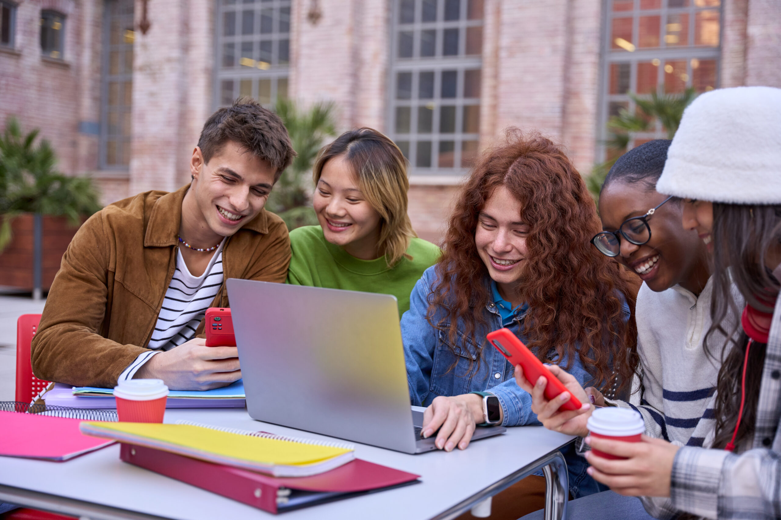 Group of happy multiracial students meeting to study together arriving at university campus