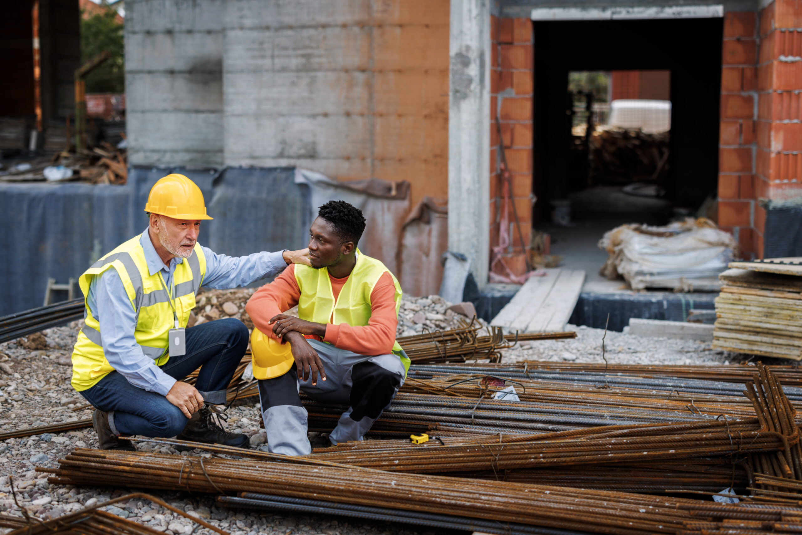 Senior man consoling his colleague at construction site